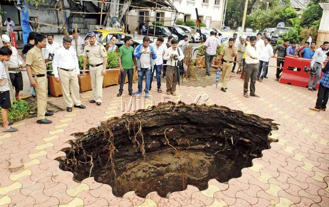 A part of a footpath caved in at Colaba, near the Radio Club. Police said that the paver blocks sank a little on June 23 and the area was cordoned off. But yesterday, there was a massive crater at the spot. Pic/Shadab Khan
