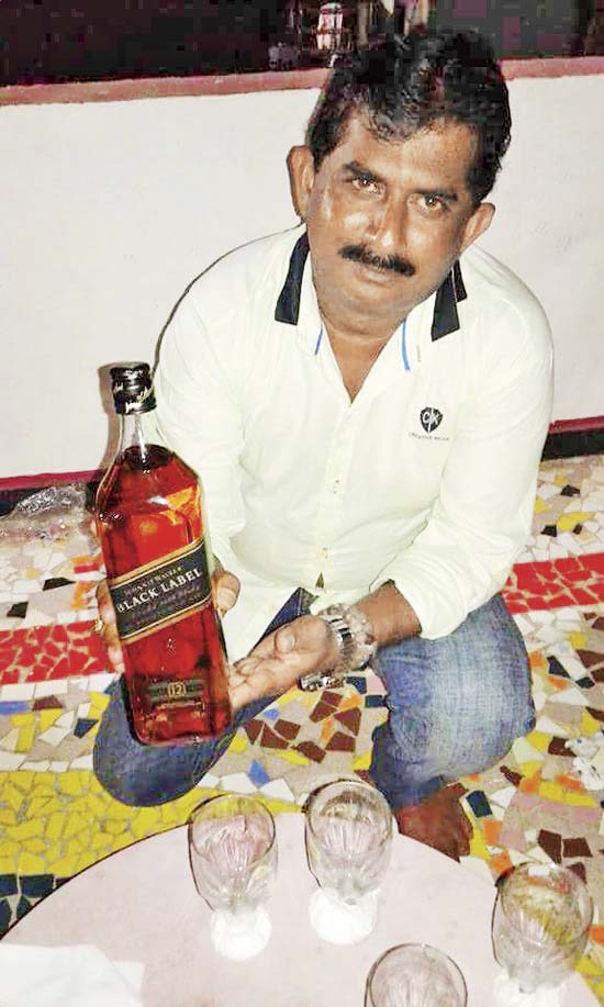 A file photo of Francis D’Mello, one of the major sellers of spurious liquor, with a bottle of scotch whisky, which costs upwards of Rs 5,800