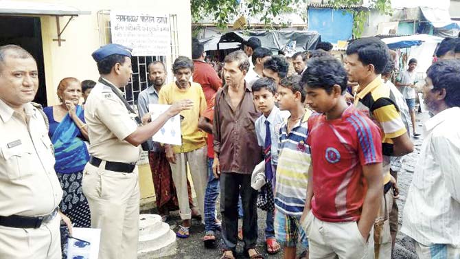 During an awareness drive in Kandivli, officials from the Samta Nagar police station show residents photos of known offenders in a bid to get information