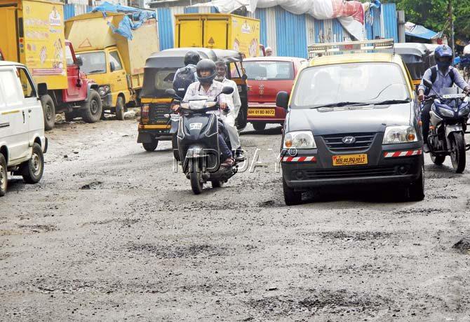 The potholes are a backbreaker for many commuters. Pic/Suresh KK