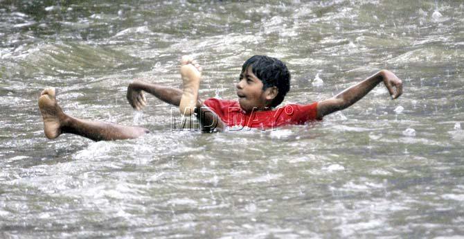 A boy plays in waterlogged Parel after a renewed spell of rain on Tuesday. Pic/Tushar Satam