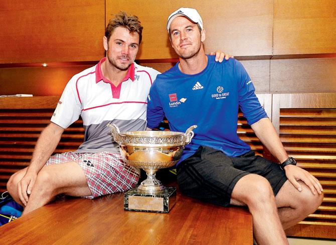  Stanislas Wawrinka poses with the French Open cup with coach Magnus Norman (right) after victory over Novak Djokovic on Sunday. Pic/Getty Images