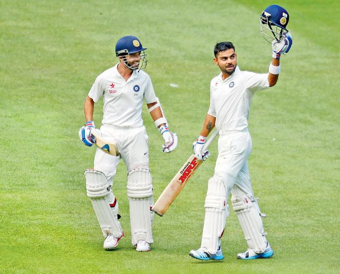 India’s Ajinkya Rahane is delighted for fellow batsman Virat Kohli, who raises his bat after completing a century against Australia in the Melbourne Test on December 28, 2014 Pic/Getty Images