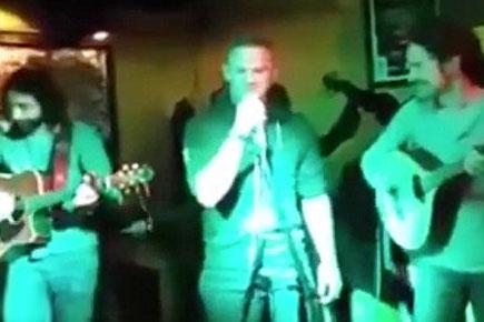 Wayne Rooney singing at a sports bar