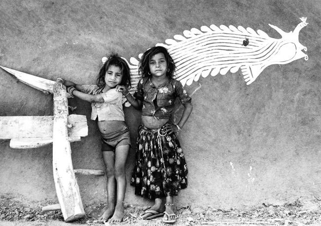 Two girls from a farming community standing near the wall of their house, Rajasthan, 1988.
