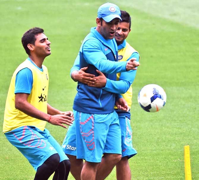 Indian cricket captain Mahendra Singh Dhoni C scores a goal as teammates Bhuvneshwar Kumar L and Suresh Raina R attempt to stop him during a game of football during a training session ahead of their 2015 Cricket World Cup quarter-final match against Bangladesh, in Melbourne. Pic/AFP