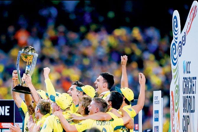 Australian players celebrate clinching the World Cup at the MCG yesterday
