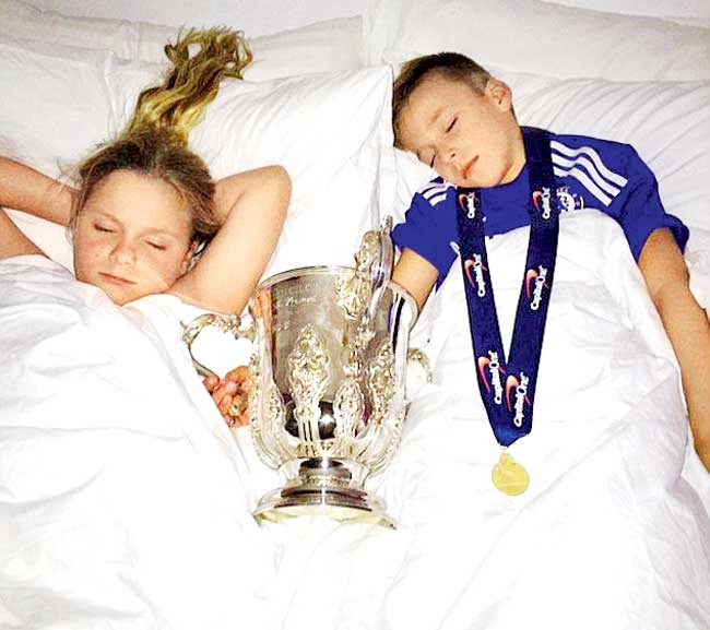 A picture Chelsea captain John Terry shared on Instagram shows his kids, Georgie John (right) and Summer Rose, sleeping next to the League Cup trophy