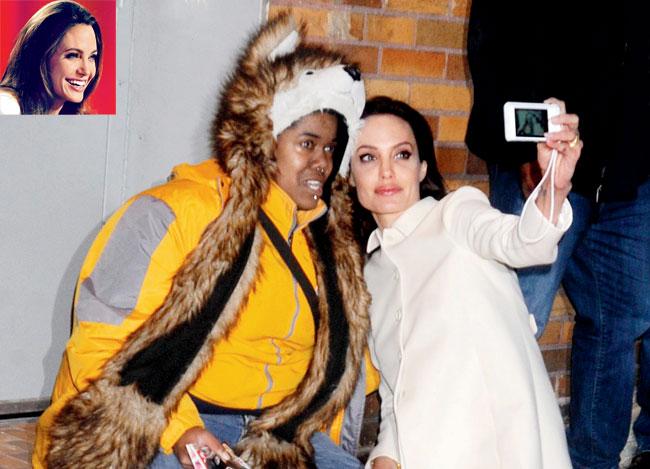 Angelina Jolie poses for a selfie with the fan. Inset: Angelina Jolie