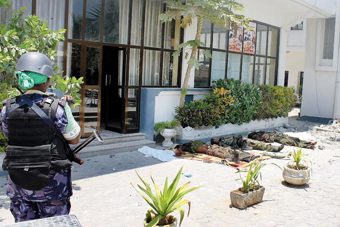 A military police woman takes pictures of three bodies of Somalia’s  Al-Qaeda-affiliated al-Shabab militants at the Maka Al-Mukarramah Hotel  in Mogadishu after Somali security forces killed them.