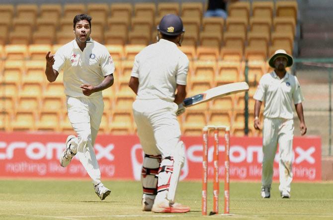 Rest of India bowler Varun Aaron celebrates the wicket of Karnataka