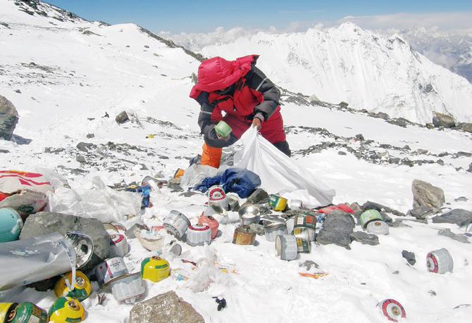A Nepalese sherpa collects garbage at an altitude of 8,000 metres during the Everest clean-up expedition in May 2010. A group of 20 Nepalese climbers collected 1,800 kilograms of garbage in a high-risk expedition to clean up the world’s highest peak.