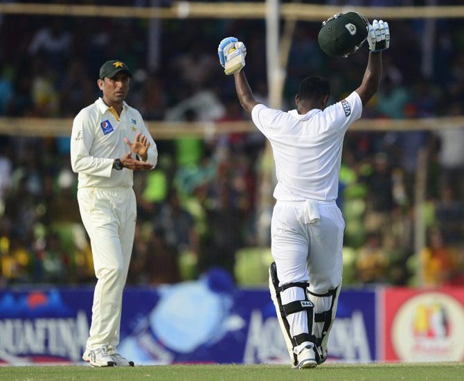 Bangladesh cricketer Imrul Kayes (R) celebrates his century as Pakistan cricketer Younis Khan (L) applauds during the fourth day of the first cricket Test match between Bangladesh and Pakistan at The Sheikh Abu Naser Stadium in Khulna. Pic/AFP