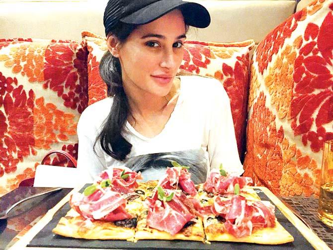 Nargis Fakhri with a prosciutto flat bread pizza, which she likes drizzled with olive oil