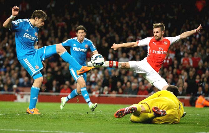 Arsenal-s Aaron Ramsey, top right, attempts to score a rebound off a Theo Walcott shot beside Sunderland-s Sebastian Coates, left, and goalkeeper Costel Pantilimon, bottom right, during the English Premier League soccer match between Arsenal and Sunderland at the Emirates Stadium in London. Pic/AFP