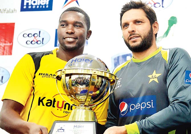 A new beginning: Pakistan T20 skipper Shahid Afridi (right) and Zimbabwe captain Elton Chigumbura pose with the T20 series trophy at Lahore