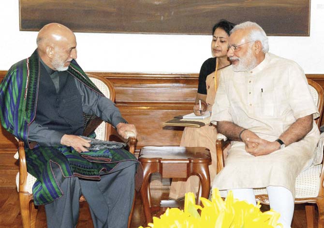 Prime Minister Narendra Modi speaks to former President of Afghanistan Hamid Karzai in Delhi, ahead of the BJP’s huge celebrations. Pic/PTI