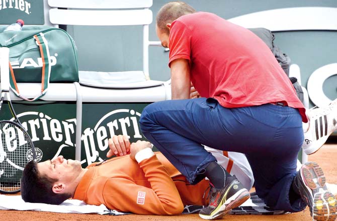Novak Djokovic receives medical treatment during his French Open second round match against Luxemburg