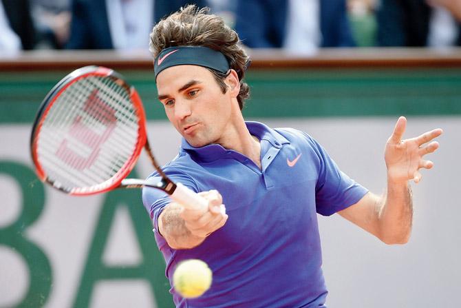 left:  Roger Federer returns to Bosnia-Herzegovina’s Damir Dzumhur during their third round match at Roland Garros yesterday