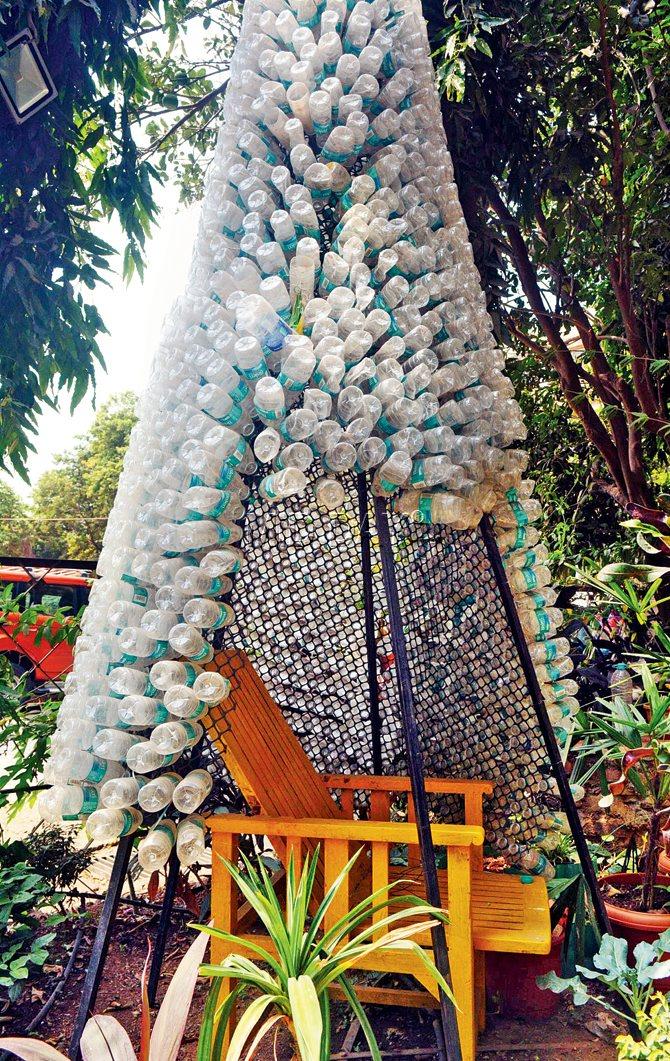 A giant Christmas Tree created out of discarded plastic bottles that also acts as a shade for seating.