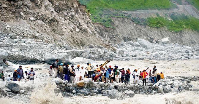 Stranded Indian pilgrims wait to be rescued on the side of a river at Govind Ghat on June 23, 2013. Bad weather hampered rescue operations and over 5,000 people were presumed dead and landslides and flash floods left pilgrims and tourists stranded without food or water. PIC/AFP