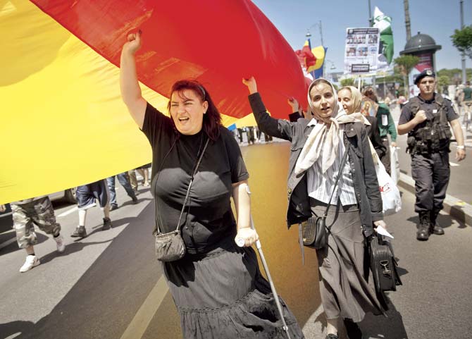 People march holding a big Romanian flag during a protest against same-sex marriages, child adoption by same-sex families and the upcoming Gay Pride parade in downtown Bucharest recently. The protest was held by the far-right extremist organisation Noua Dreapta, which means The New Right
