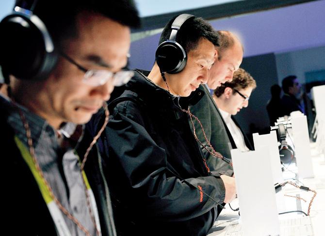 Attendees try headphones at the 2015 International CES at the Las Vegas Convention Center on January 6, 2015 in Las Vegas, Nevada.  