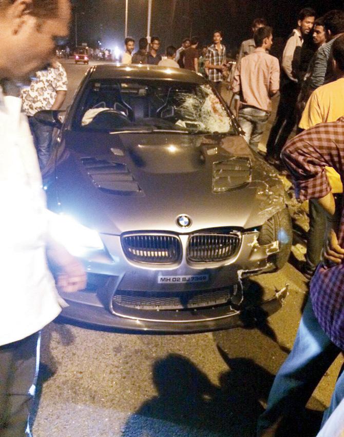Locals look at the BMW after the accident