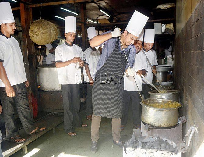 Omaer Shaikh prepares the traditional Dum Pukht Biryani on coal stoves in the kitchen