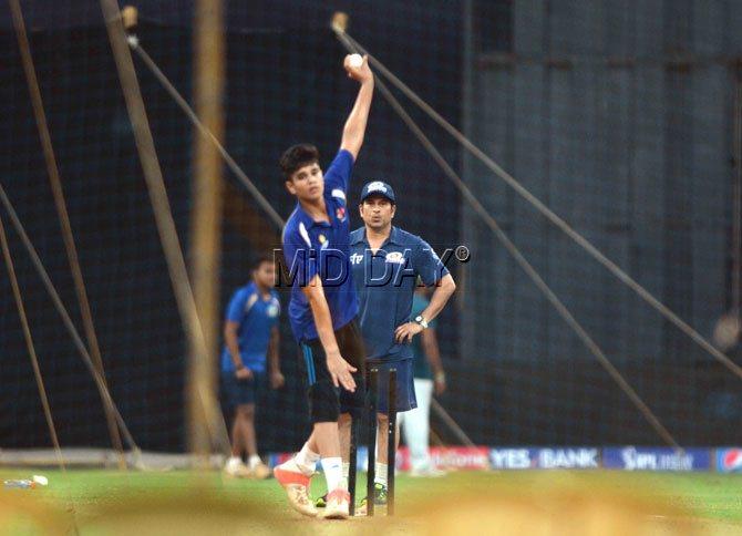 Sachin Tendulkar watches as his son Arjun trains with Mumbai Indians team at Wankhede stadium on Wednesday. 