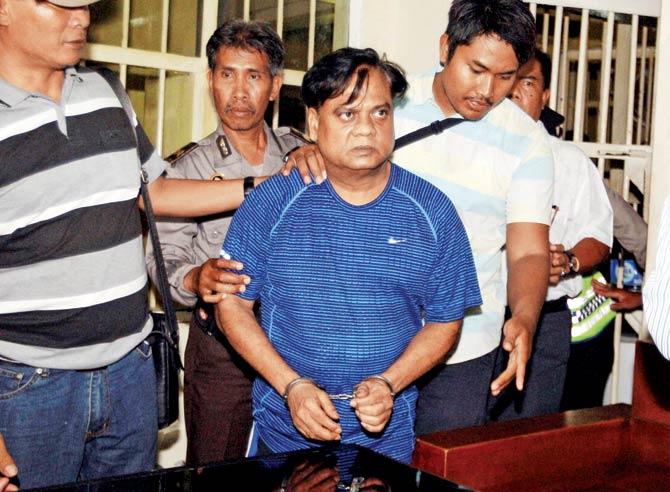 Chhota Rajan escorted by police officers to Bali airport on Thursday to be deported to India. Pic/PTI