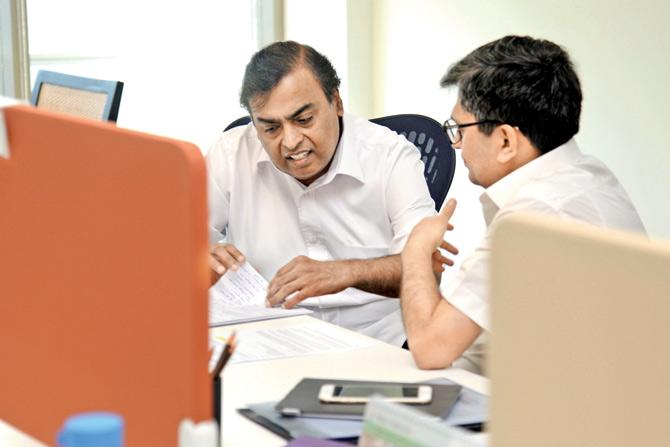 Mukesh Ambani at his desk beside Manoj Modi in the open office of Reliance Jio Infocom in Navi Mumbai where he and 70 top leaders will now operate from