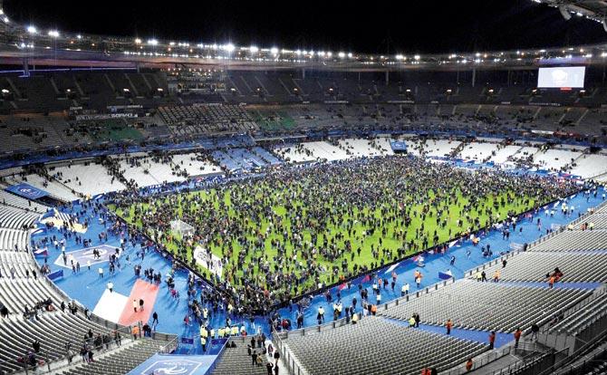 Spectators gather on the pitch following a friendly match between France and Germany in Paris. Pic/AFP
