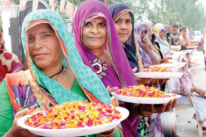 Village women wait to welcome SP chief Mulayam Singh Yadav on his 77th birthday in Saifee on Saturday. pic/PTI