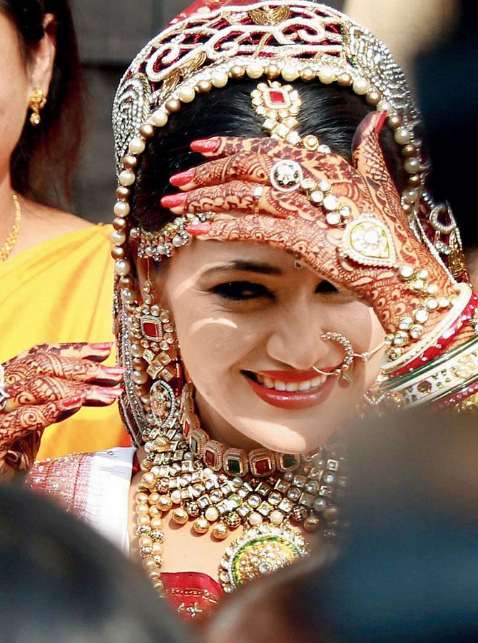 Disha Vakani wore a red lehenga with heavy jewellery and made for a pretty bride.