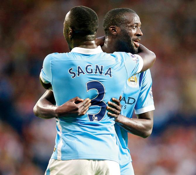 Manchester City’s Yaya Toure (right) embraces teammate Bacary Sagna
