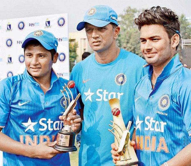Man of the match Sarfaraz Khan (left) and man of the series Rishab Pant (right) pose with coach Rahul Dravid yesterday. Pic/PTI