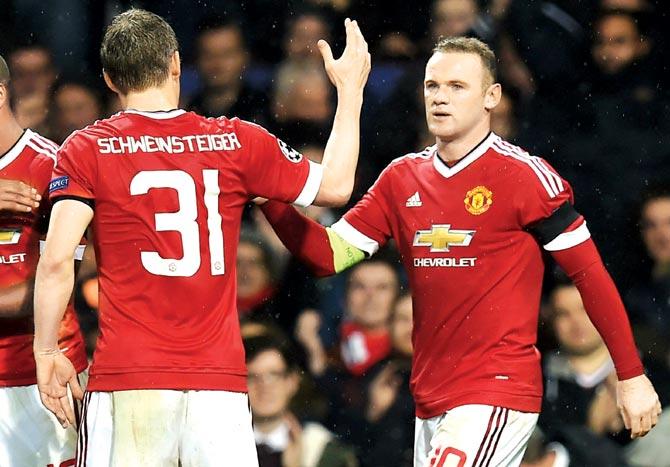 Man United striker Wayne Rooney celebrates his goal against CSKA Moscow with teammate Bastian Schweinsteiger (jersey No 31) in Manchester on Tuesday night