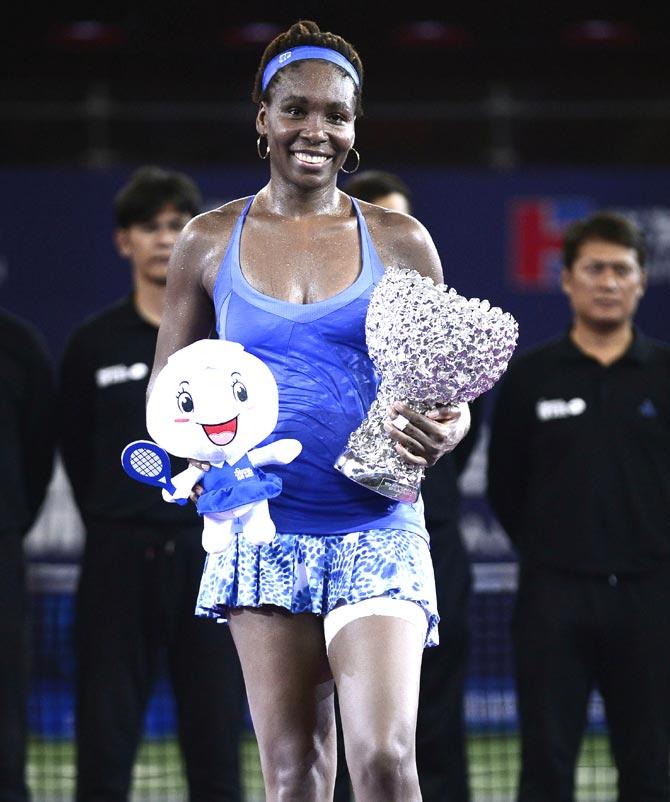 Venus Williams of the US poses with her trophy after winning the women