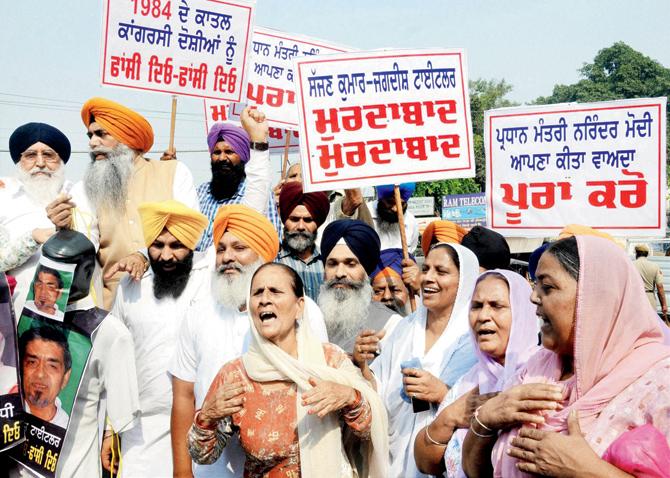 We want justice! Protesters hold placards and shout slogans demanding punishment for perpetrators of the Sikh genocide in 1984, during a rally organised from Golden Temple to Hall Gate in Amritsar yesterday. Pic/Pti 