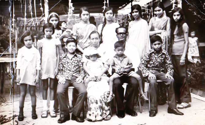 This is a photograph of Narayan Muthu from Vathalagundu in Madurai and his wife Lim Ah Chwa. During the early 1940s, Narayan was transferred to Malaya by the British government. Narayan’s family couldn’t accept the marriage and even got him married to a woman of their caste when he’d made a short trip home. Upset, he never spoke of that incident till the day he died. However, Narayan still missed the presence of his own family in his new life in Malaysia. To remind himself of his family, he decided to name all his 13 children after the names of his family members in India. 