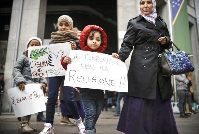 Children hold posters reading ‘Islam is Peace’, ‘Terrorism has no religion’ during a demonstration