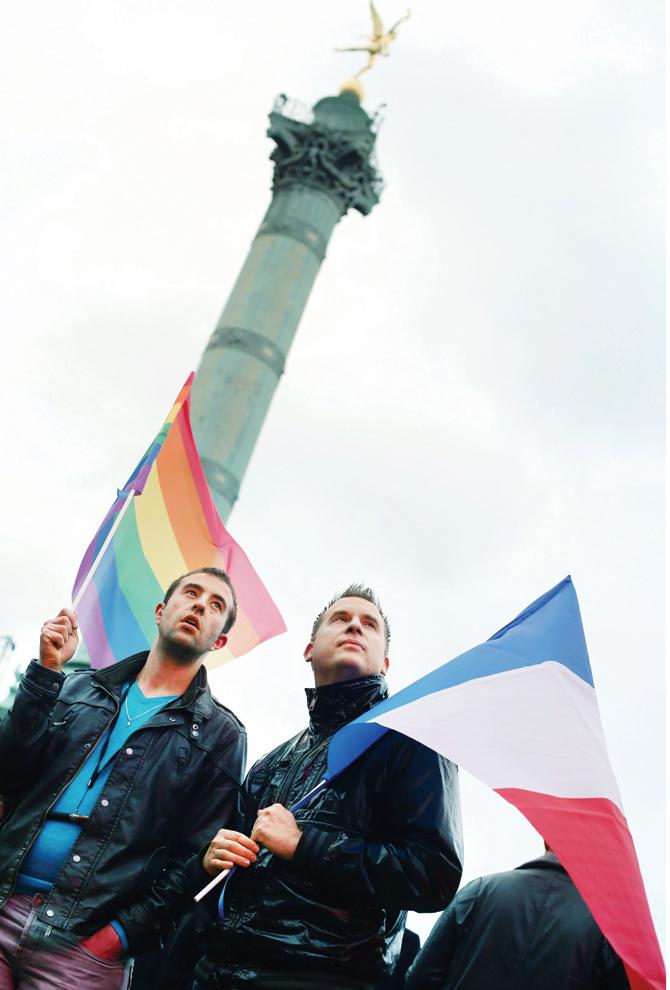 Two gay men hold a rainbow flag and the French national flag during an event in support of the gay community in Paris.  Pic for representation/AFp