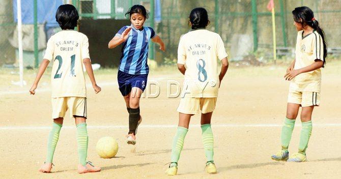 Diti Kanungo of NSS Hill Spring International (in blue) tries to get past three St Anne’s (Orlem) defenders during their MSSA Girls U-14 Division-II quarter-final encounter at Azad Maidan yesterday. NSS Hill Spring won 2-0. PIC/SHADAB KHAN 