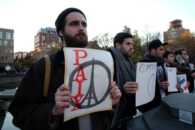 People display placards during a vigil to show solidarity with the citizens of France in New York, a day after the Paris terrorist attacks