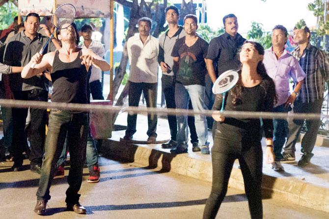 (Above and below) Shah Rukh Khan (left) plays badminton on the sets
