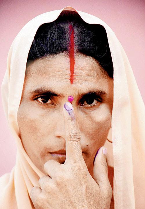 A woman flaunts her inked finger after casting her vote.  PIC/PTI