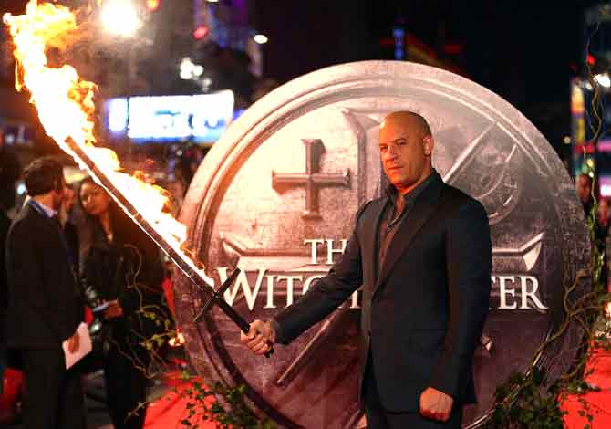 Vin Diesel holds a flaming sword as he arrives on the red carpet to attend the European premiere of 
