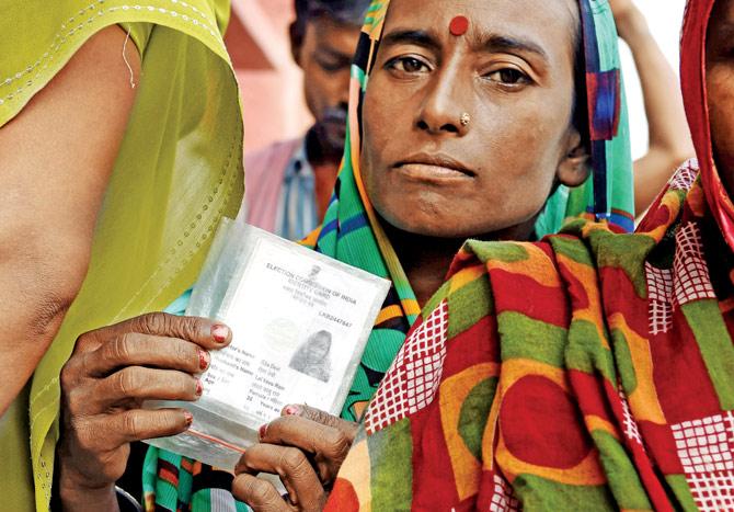 A voter holds up her voting card before casting her ballot at a voting centre in the village of Banbira, Bihar on October 12, 2015. pic/AFP 