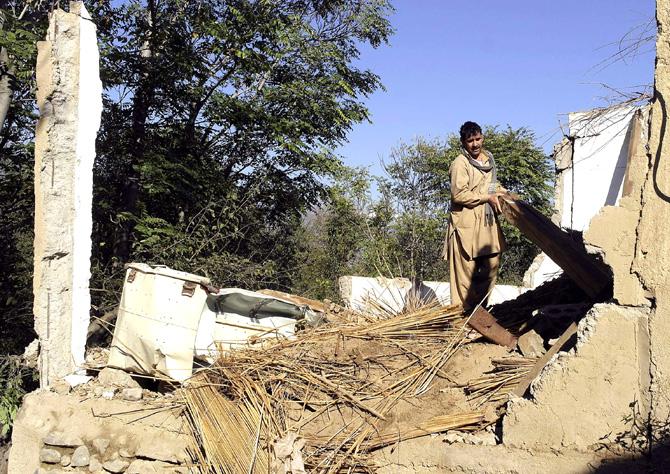 A Pakistani resident removes belongings from the rubble of a house following an earthquake in Lower Dir. Pic/AFP